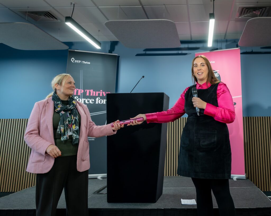 Left, Zoe Ferris Head of Organisational Development and Engagement at Amplius, accepts the baton from PfP Thrive's head of partnerships Jen Radcliffe